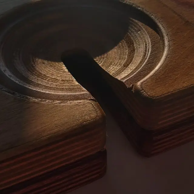 Close-up of the bowled wine-glass notch cut into a board edge, with the ply layers visible in the cut.
