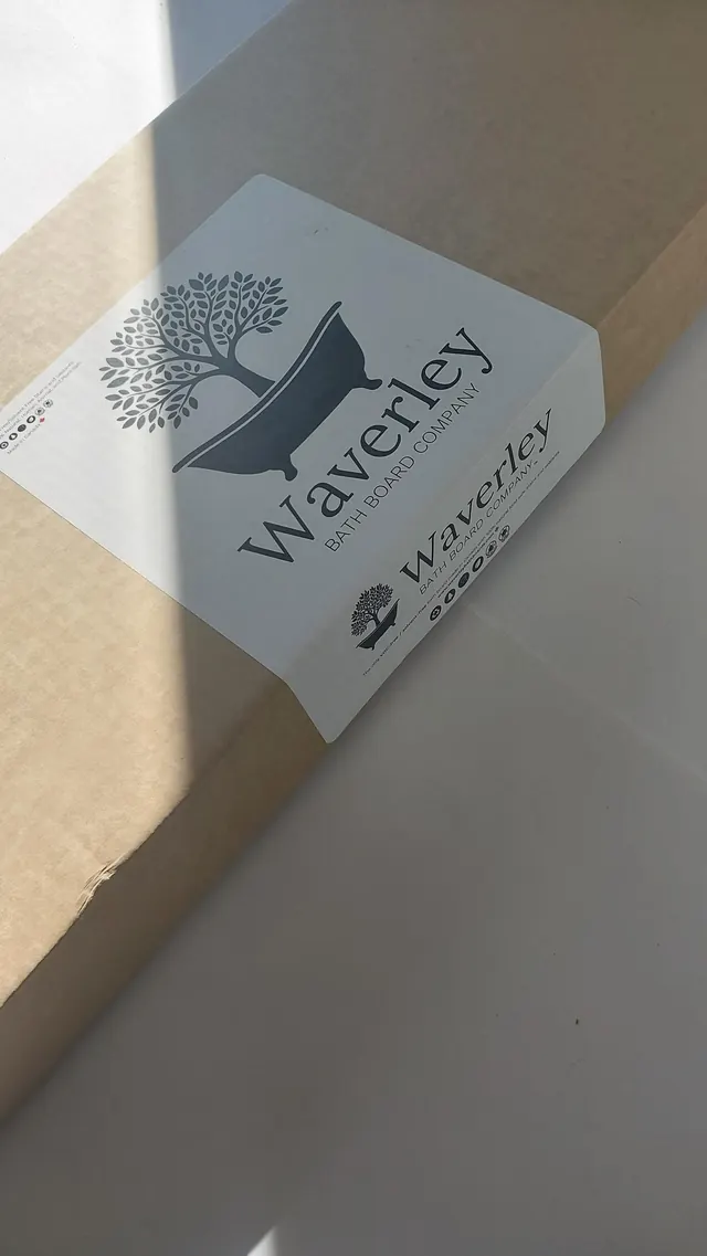 A finished board boxed for shipping, the Waverley label catching low sunlight across the top of the carton.