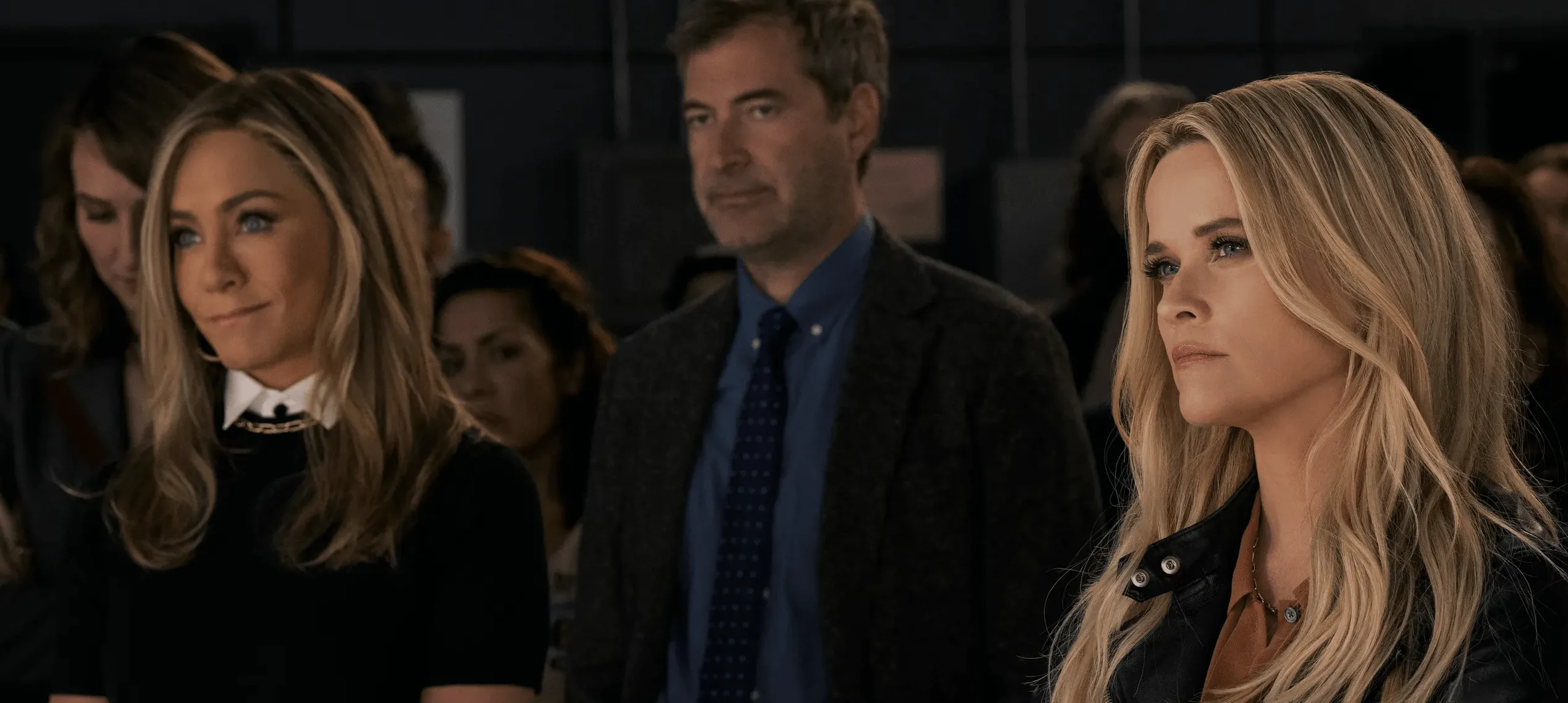 Jennifer Aniston, Mark Duplass and Reese Witherspoon standing in a television newsroom